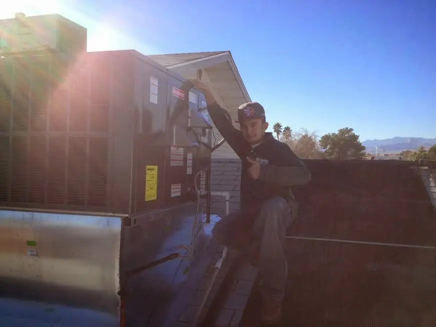 HVAC technician performing Heat Pump Repair on a rooftop unit in Odenton